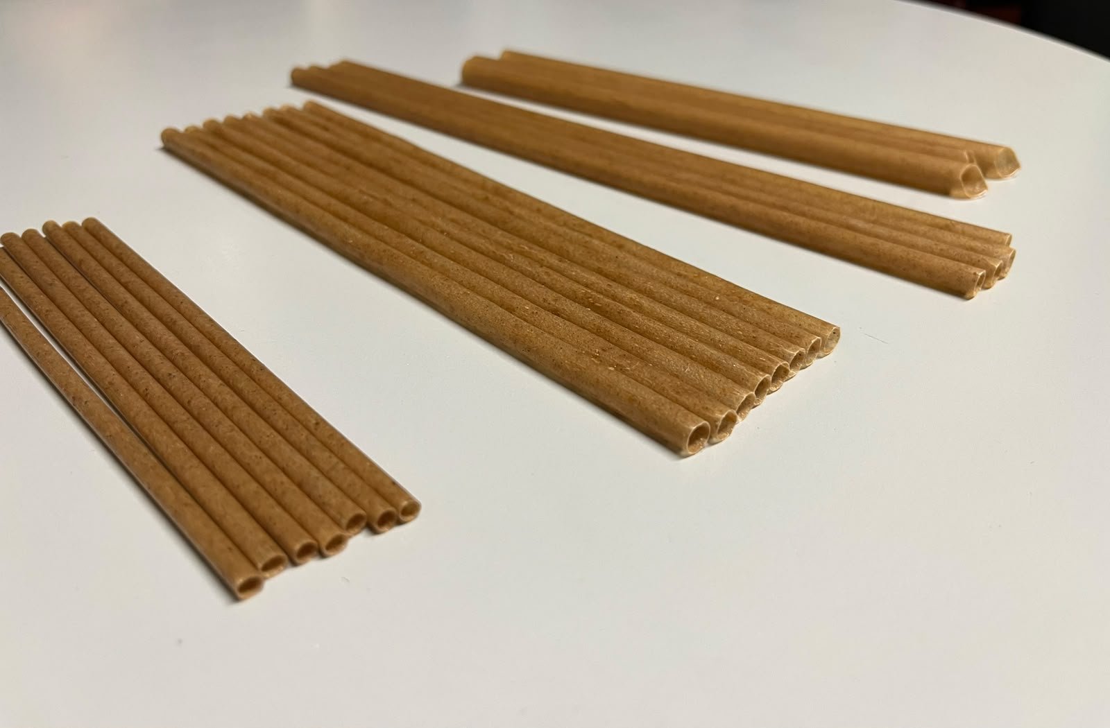 Popotes de fibra de agave acomodados en abanico sobre fondo neutro.